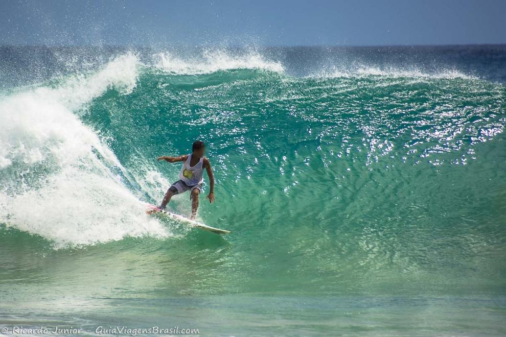 Imagem de um surfista na base da onda.